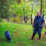 Truffle hunter with dog searching in the woods