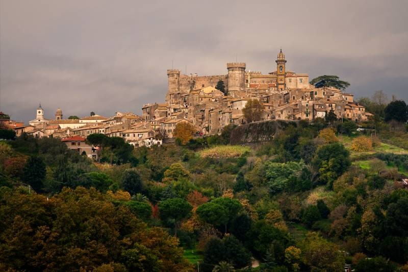 Lazio Province, Italy: View of Orsini Castle and Bracciano village surrounded by forest in autumnal 