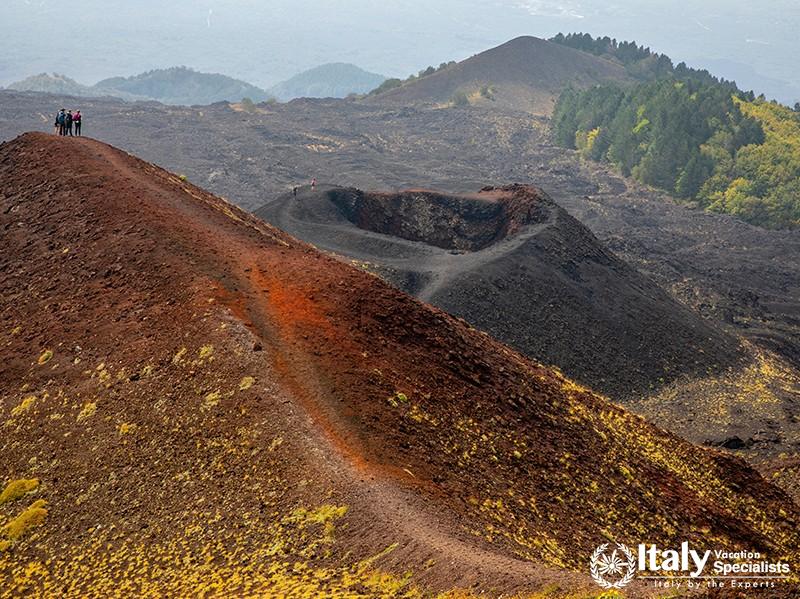 Mount Etna craters with a group of hikers at a peak