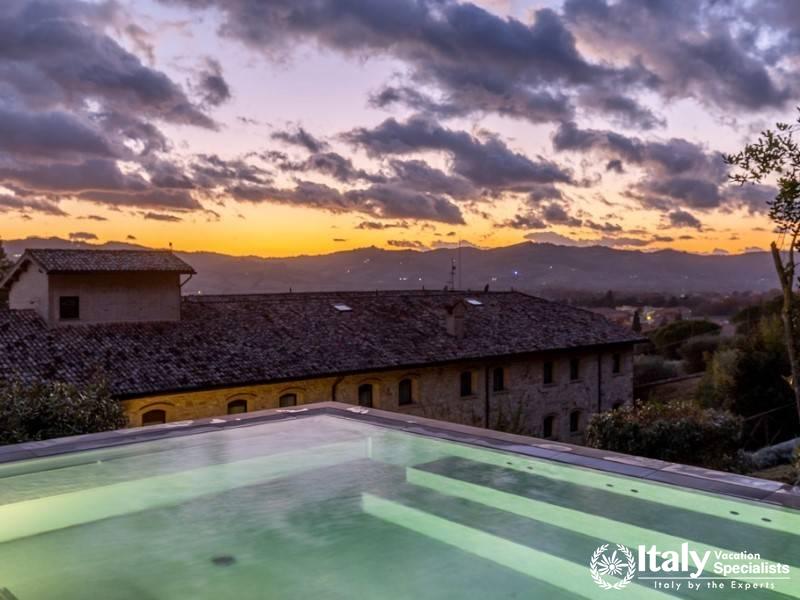 Breathtaking view of the sunset over the serene countryside from the tranquil pool area.