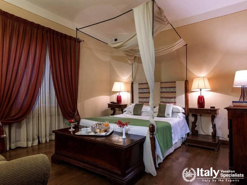 A warmly decorated room with a canopy bed and classic wood furniture, radiating old-world charm.