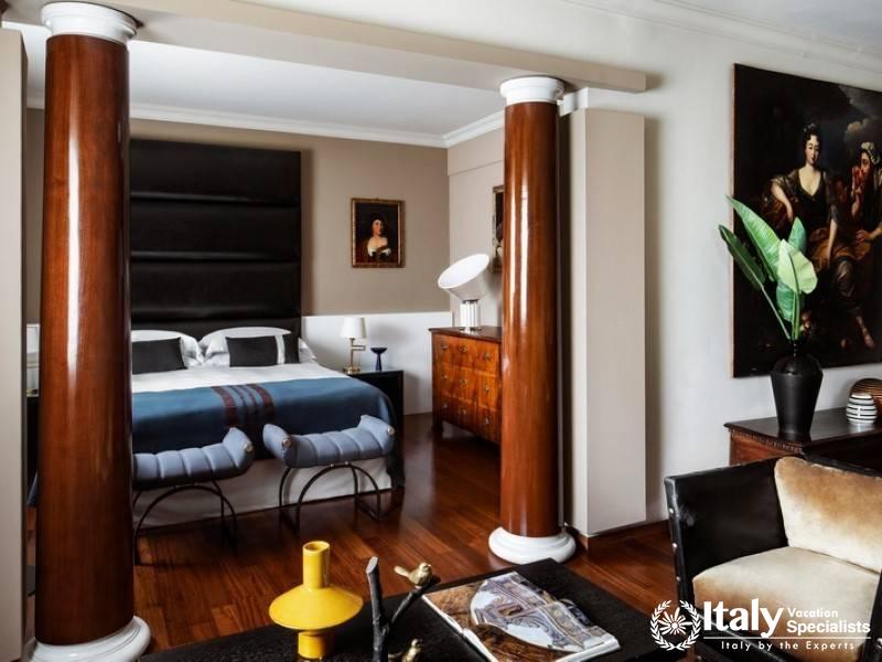 Elegant bedroom adorned with classical columns and rich wooden furnishings.