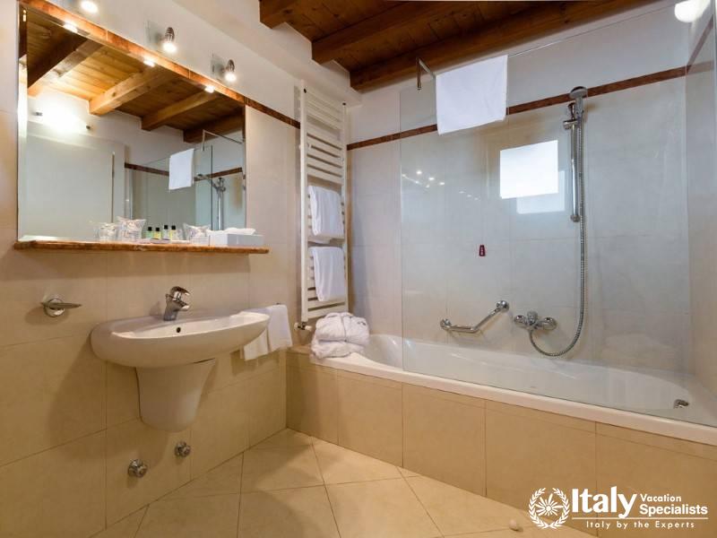 A clean, well-lit bathroom with a modern bathtub, warm wood accents, and a large mirror.