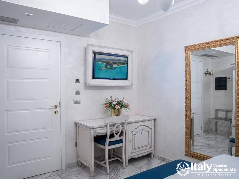 Cozy corner with a modern desk and TV in a room at Hotel Colomba D'Oro in Tropea, Italy