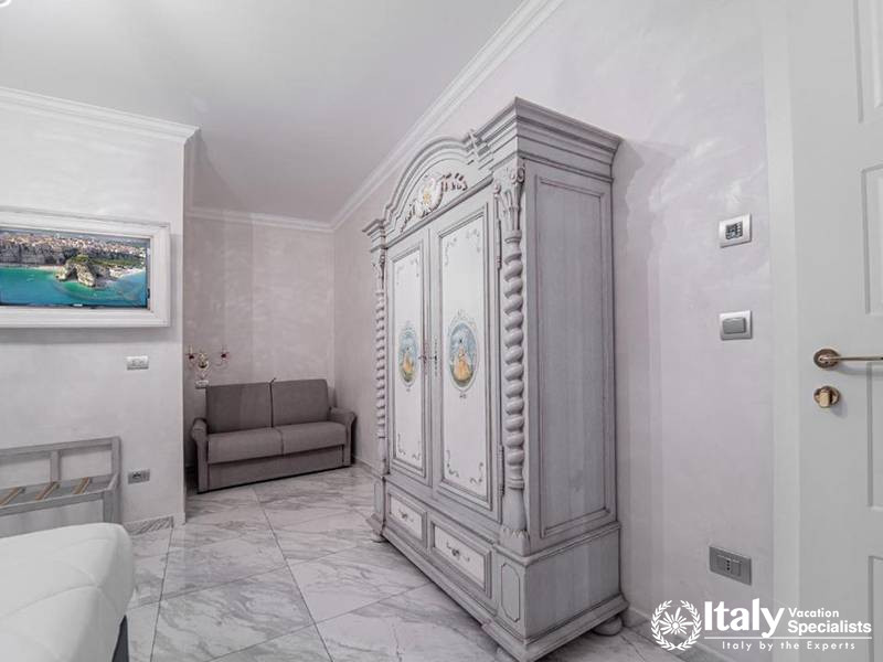 Charming wardrobe and TV setup in a guest room at Hotel Colomba D'Oro in Tropea, Italy