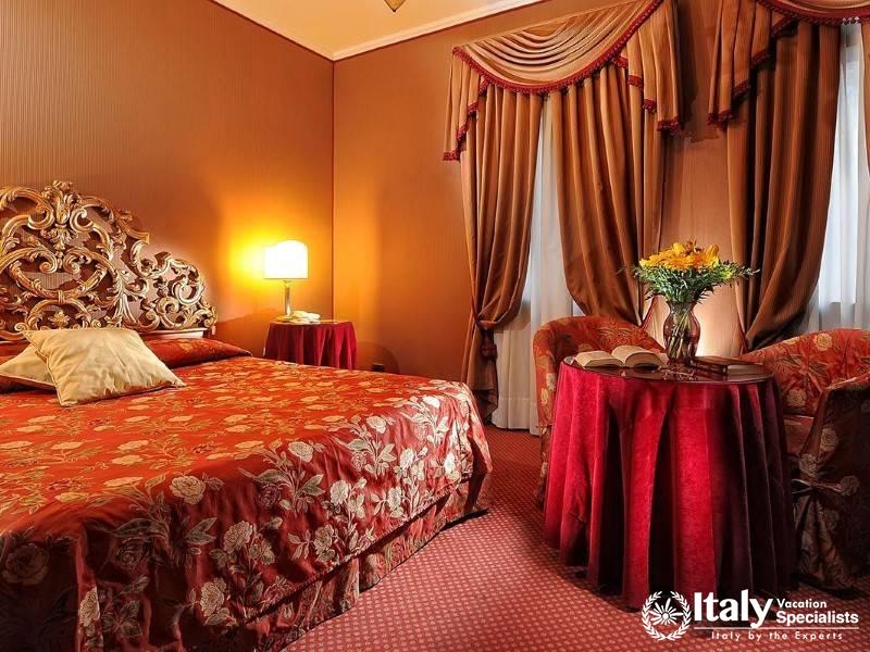 Warm, romantic bedroom with rich red and gold accents and elaborate headboard.