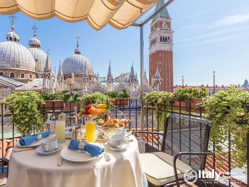 Spectacular rooftop dining area overlooking historic domes and a famous bell tower.