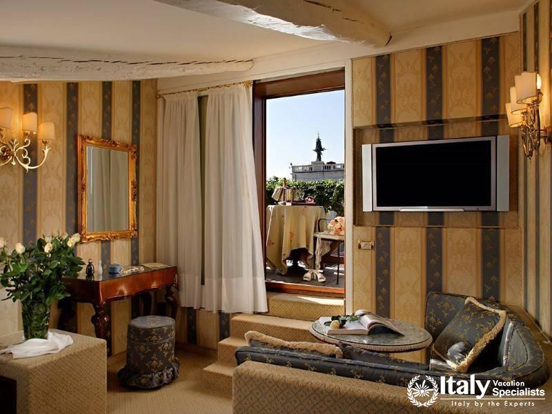 Luxurious living area with classic striped wallpaper and a scenic outdoor balcony.