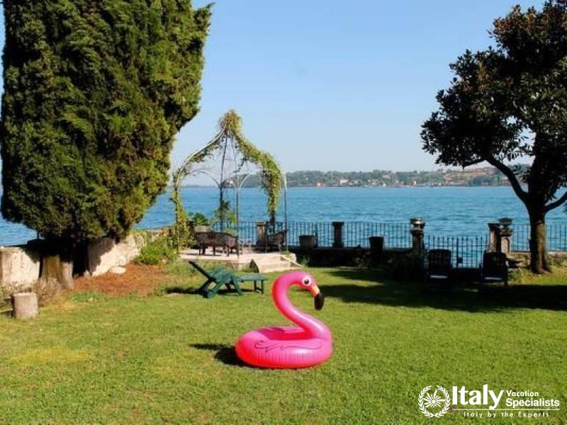 Lakeside Bliss: Tranquil garden with direct lake access and playful flamingo float near lake Garda