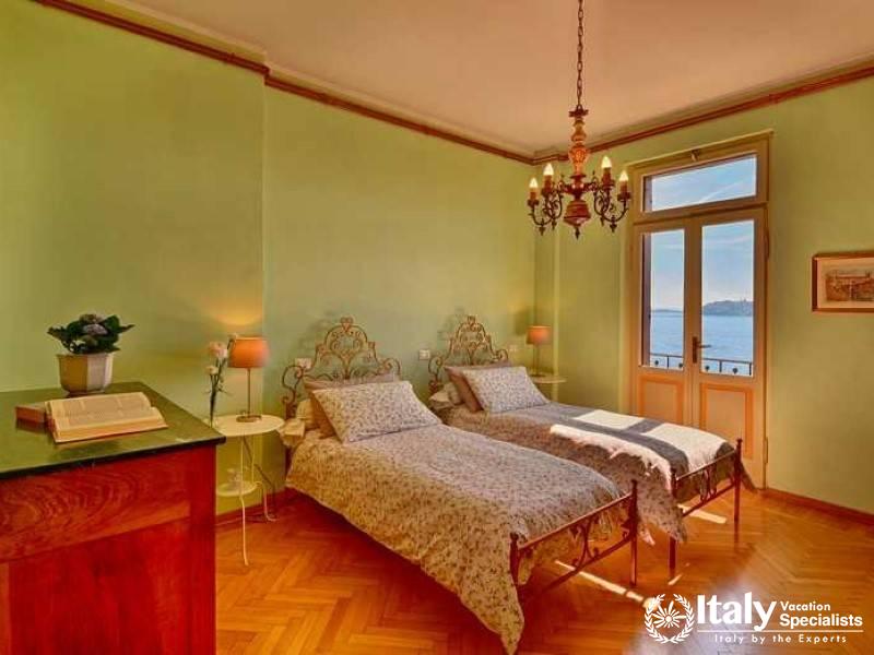 Vintage Charm: Twin bedroom with antique beds and lakeside balcony in Villa Lago Elegante