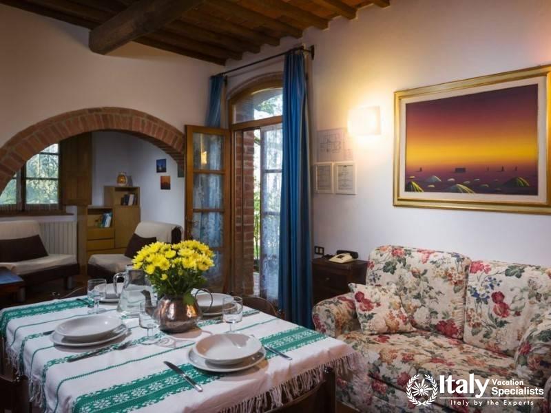 Charming dining space with arched entryways and vibrant window curtains.