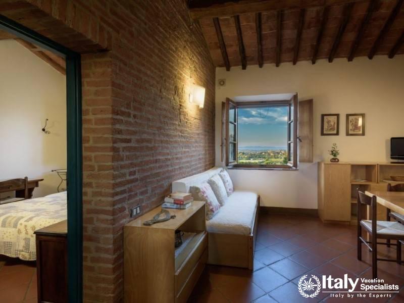 Spacious studio layout with a bed near the window offering sweeping views of the surrounding area.