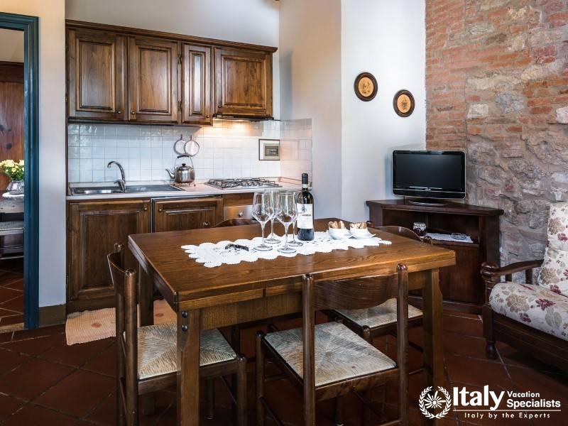 Traditional dining space with a rustic kitchen and a small TV for entertainment.
