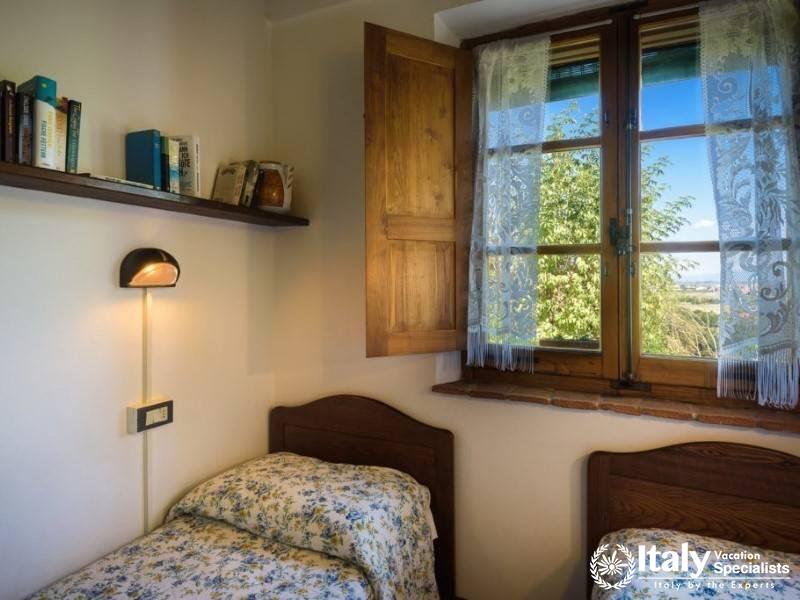 Twin bedroom with a serene view, wooden shutters, and a homely atmosphere.