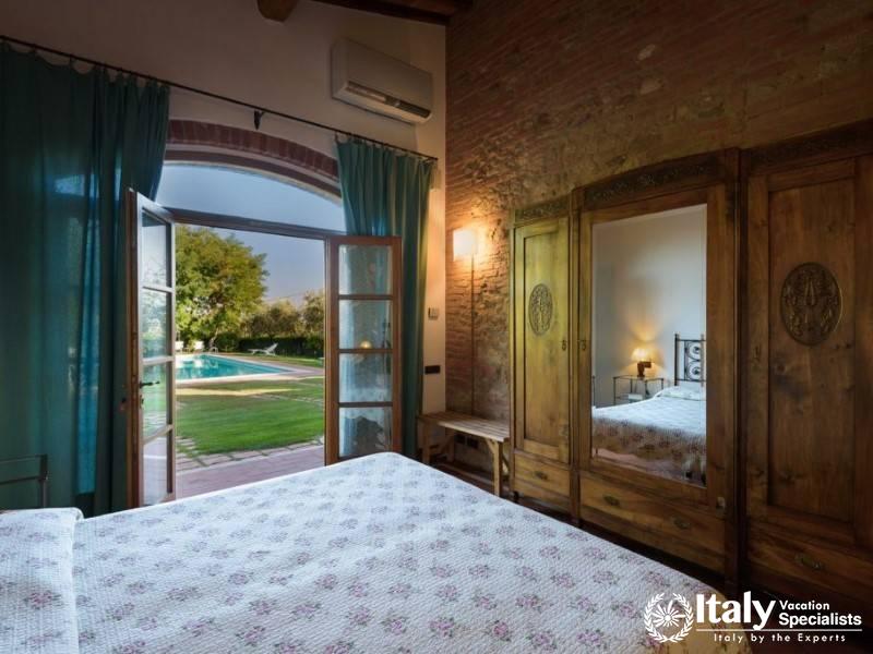 Soft linens and vintage furniture, opening directly to the garden.