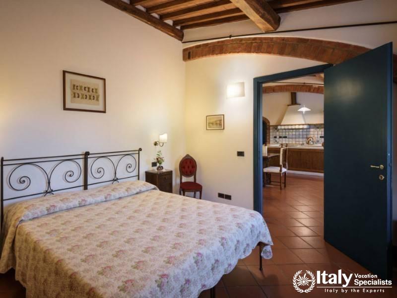 Bedroom with direct kitchen access, featuring a classic wrought iron bed and elegant furnishings.