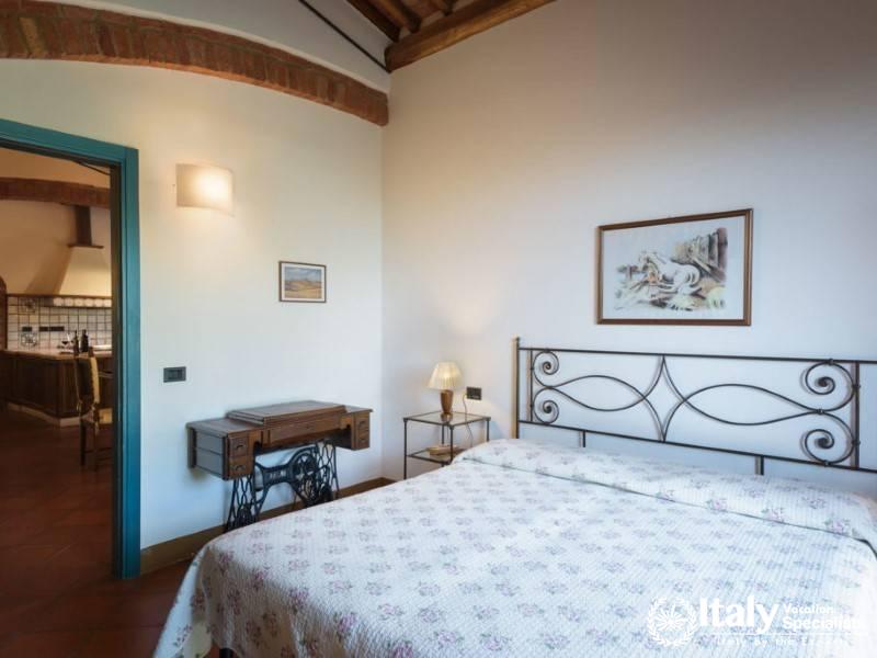 Inviting bedroom with a view into the kitchen, enhanced by traditional dÃ©cor and natural light.
