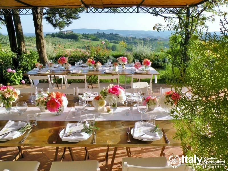 Outdoor dining with countryside view and floral decor.