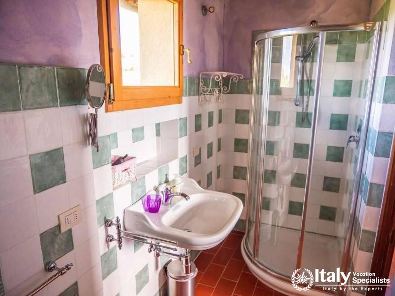 Compact bathroom with a corner shower and checkerboard tiles.