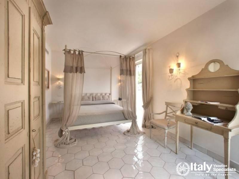 An elegant bedroom suite with a canopy bed and vintage furnishings.