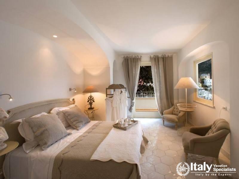 A cozy and elegantly furnished bedroom with a beautiful view.