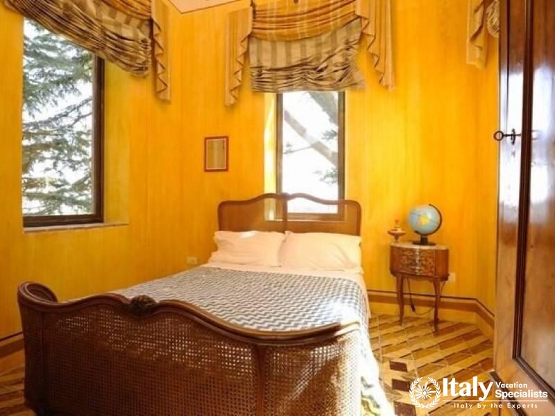 Cozy bedroom with yellow walls and wooden furniture.