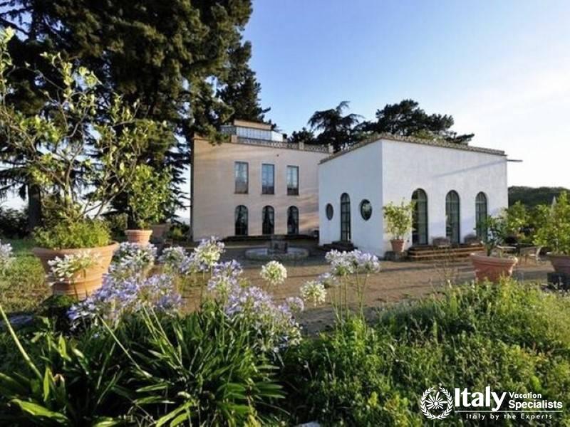 Charming villa surrounded by lush gardens and flowers.