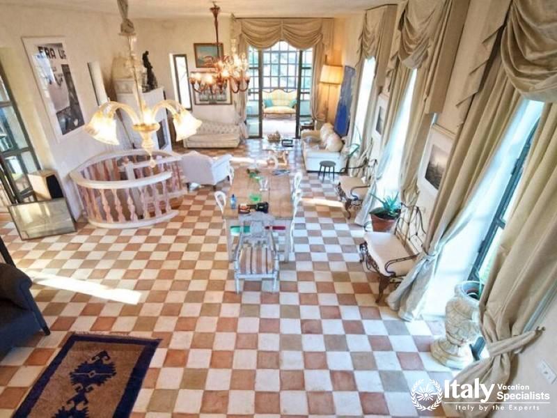 Spacious and elegantly decorated living room with a checkered floor.