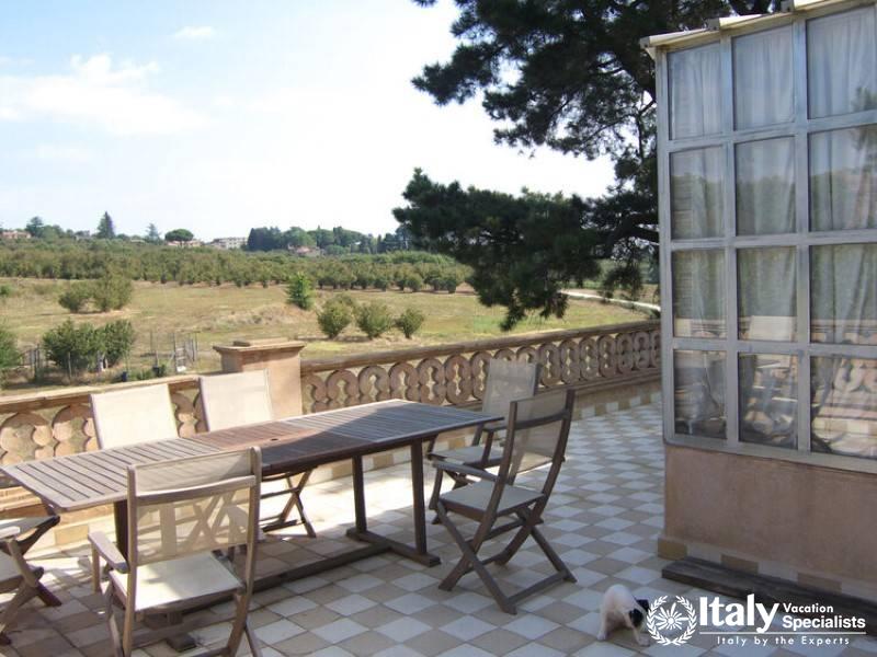 Outdoor terrace with a dining table and countryside view.