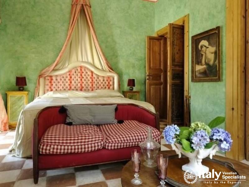 Charming bedroom with a red sofa and canopy bed.