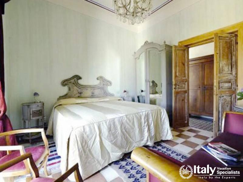 Vintage-style bedroom with ornate headboard and wooden doors.