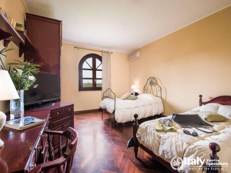 Spacious twin bedroom with elegant wooden furniture and serene views.