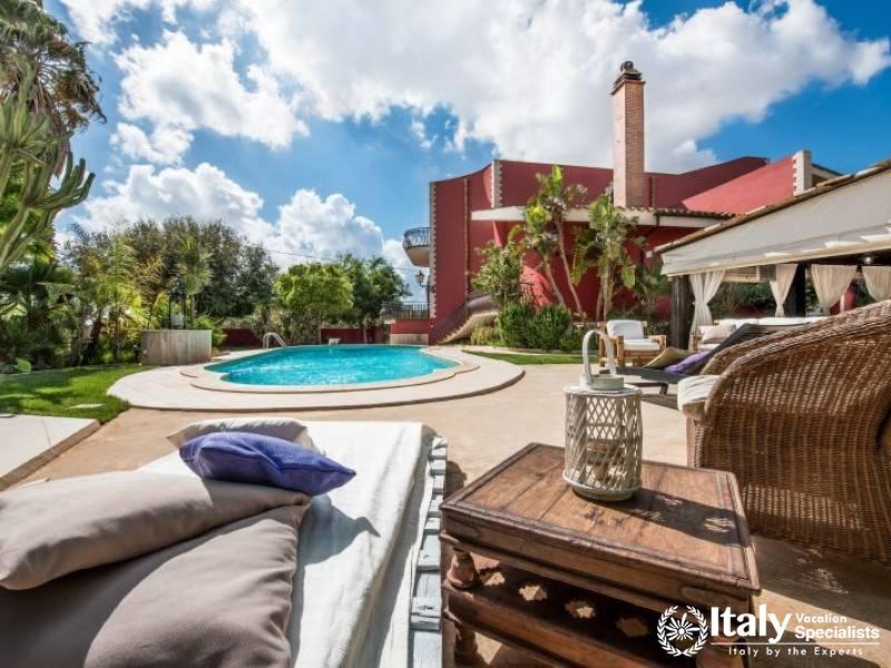 Relax by the pool in a serene outdoor lounge with a view of the villa.