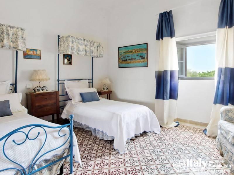 A cozy bedroom at Villa Sole di Marsala with charming blue accents.