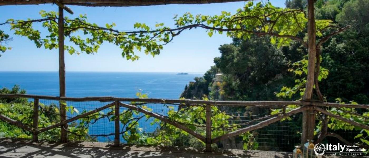 A rustic pergola offering a picturesque view of the sparkling blue Mediterranean Sea.