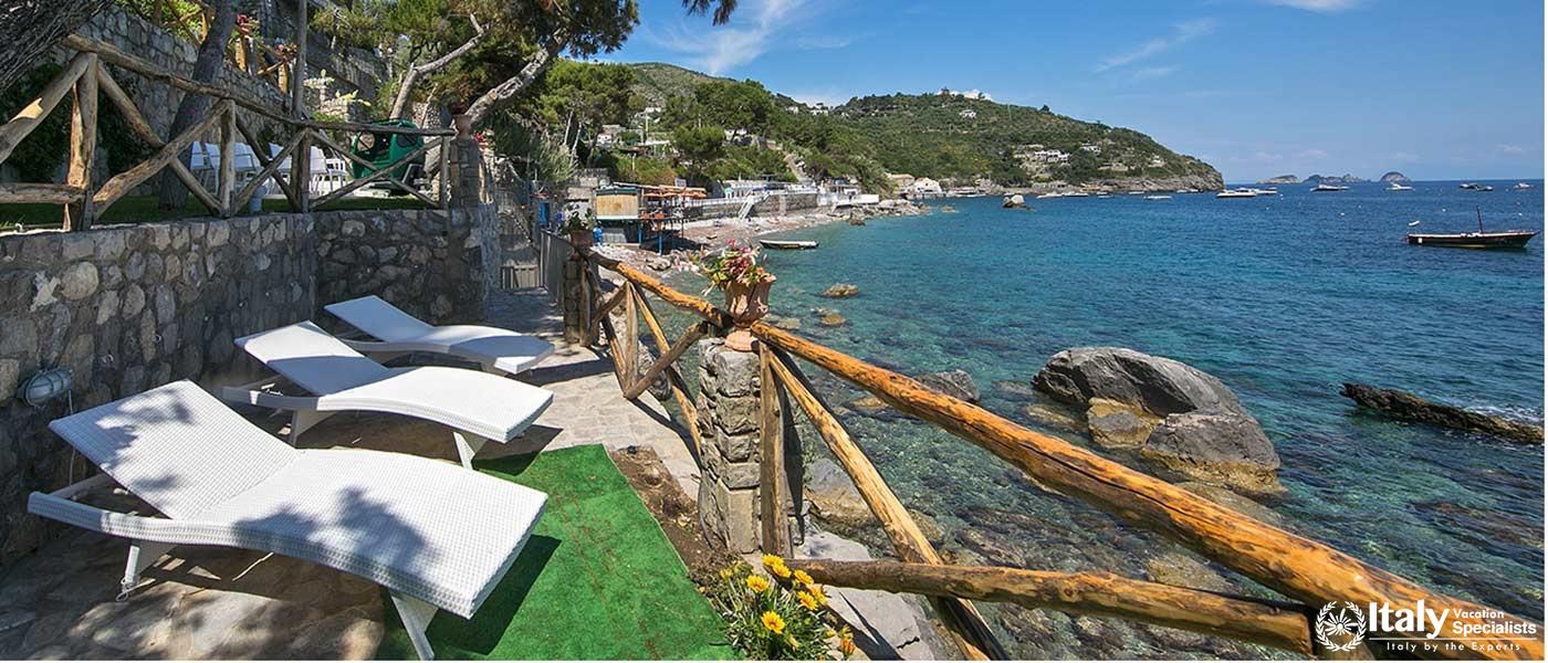 Relaxing sun loungers by the rocky coastline.