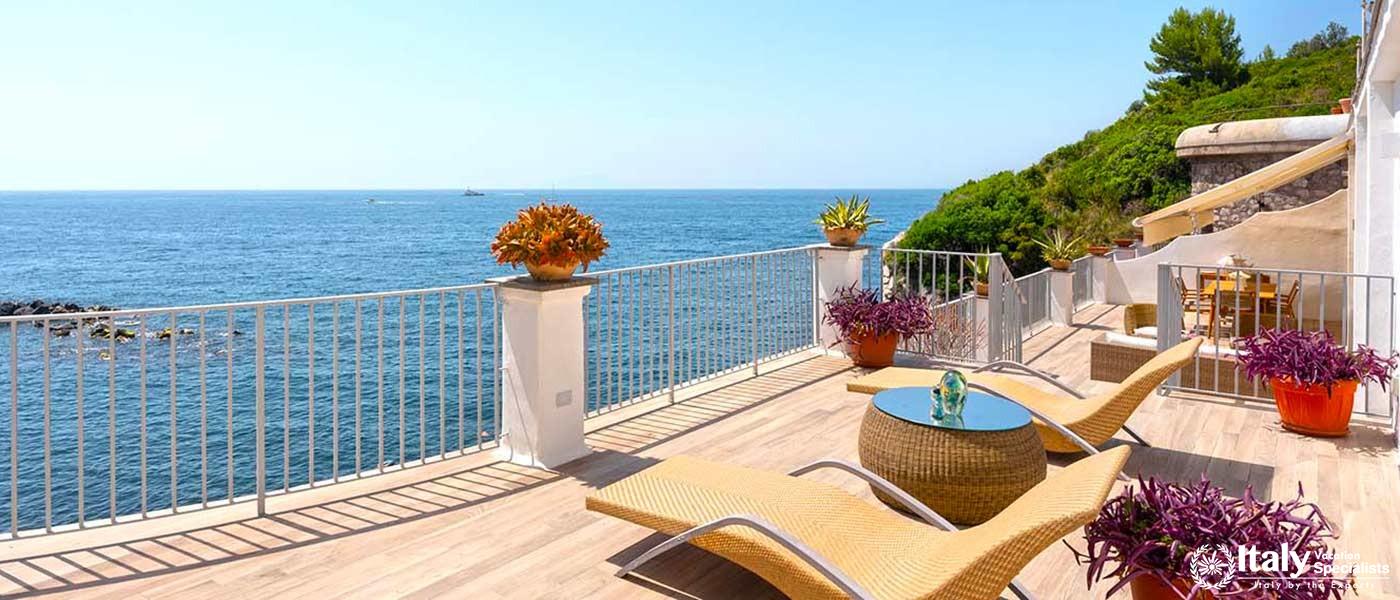 A sun deck featuring comfortable loungers and a panoramic ocean view.