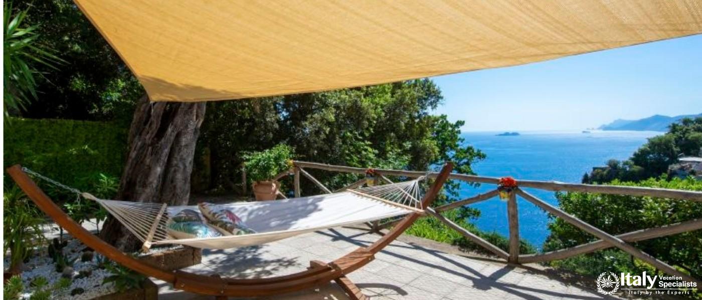 A cozy hammock shaded by a canopy, overlooking the vast horizon and peaceful waters.
