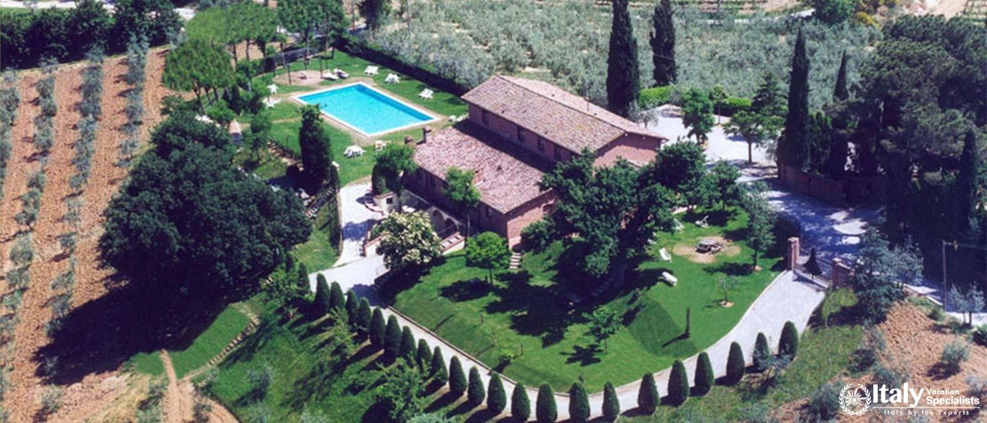 An aerial view of a villa with a pool and manicured gardens.