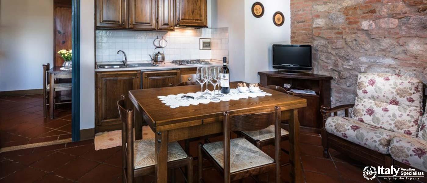 A cozy, traditional kitchen and dining area with exposed brick and wooden furniture.