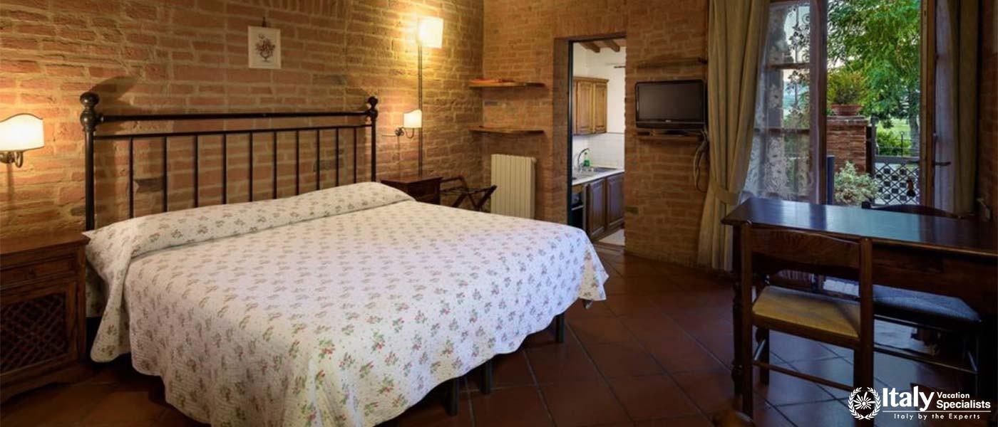 A cozy, rustic bedroom with a view of the garden through a French window.