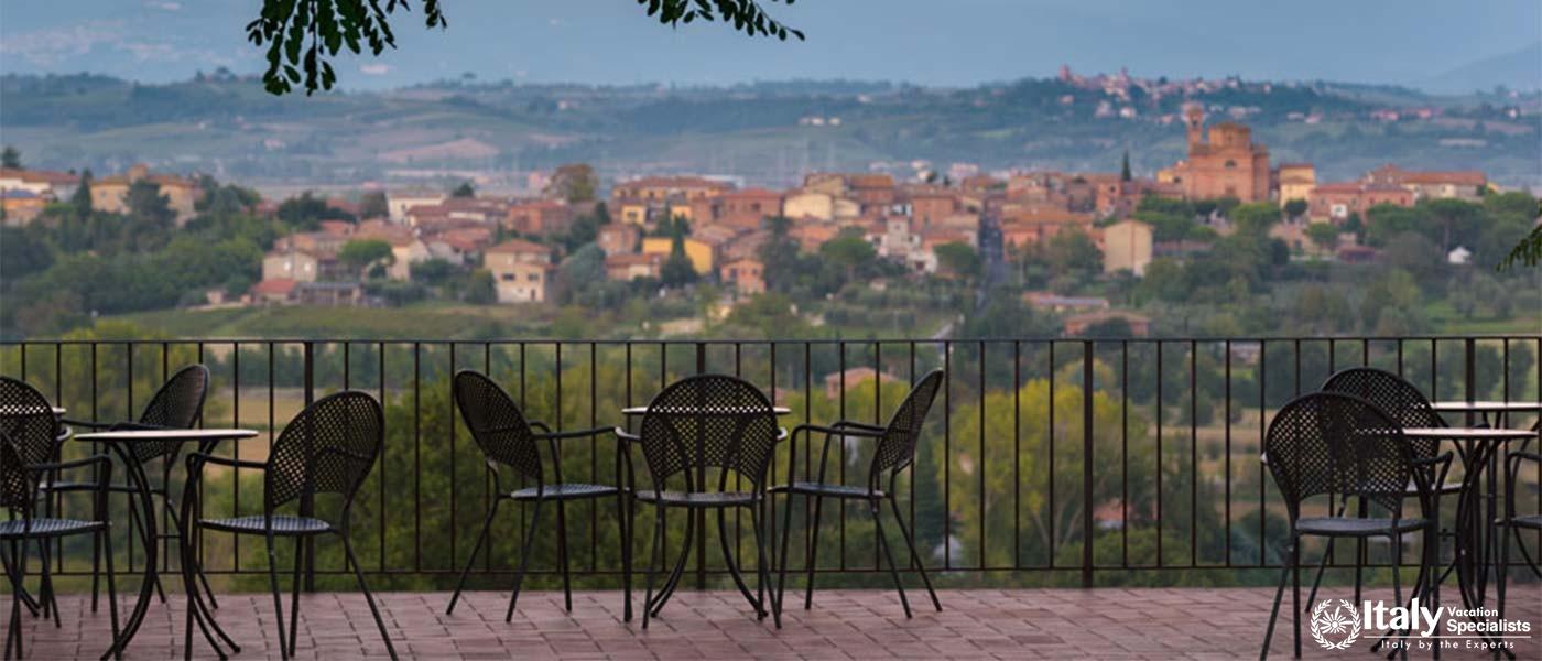 A terrace with tables and chairs offering panoramic village views.