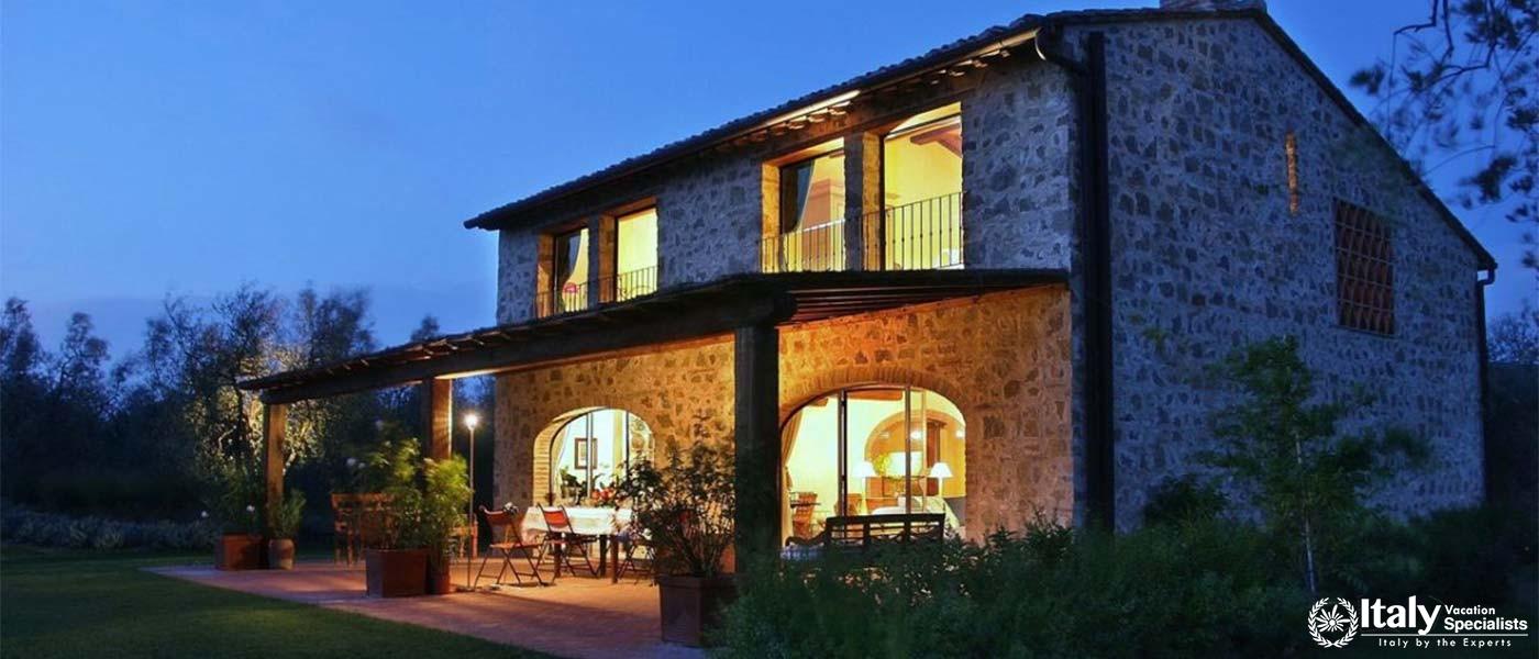 Charming stone villa illuminated at dusk, offering a cozy ambiance near Florence, Italy.