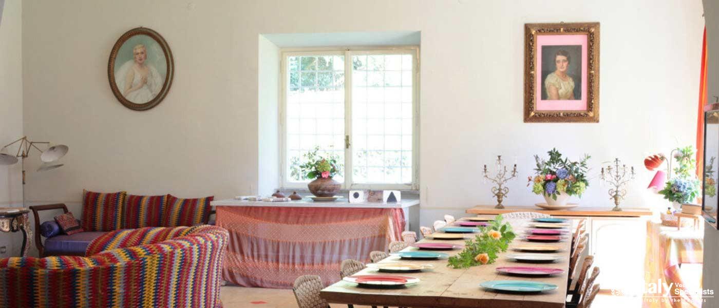 A vibrant dining room with a grand fireplace and colorful decor.