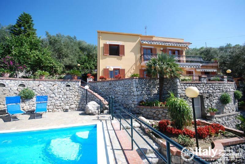 Outdoor swimming pool and sitting area in Villa Rocio