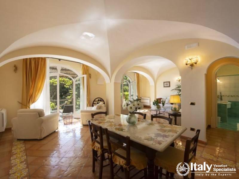 Spacious living and dining room featuring arched windows and doors.
