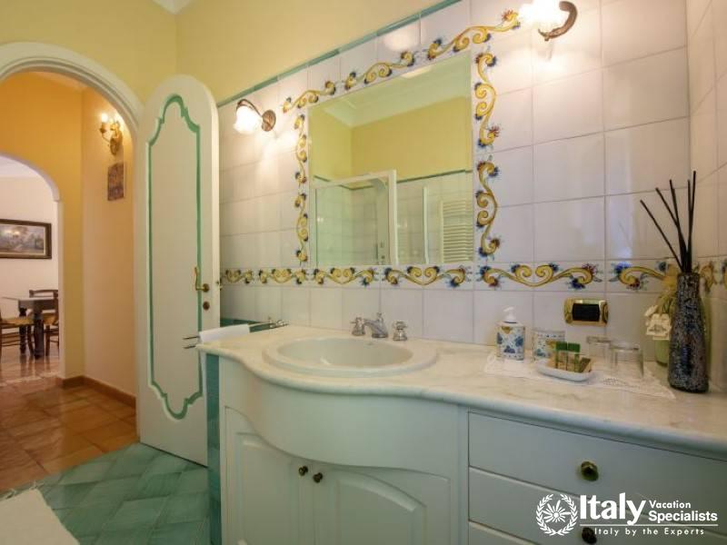 A stylish bathroom with vibrant Mediterranean tile accents and a bright, inviting ambiance.