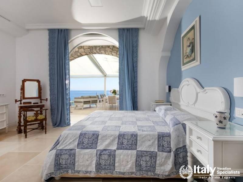 Spacious blue bedroom with direct access to an outdoor seating area.