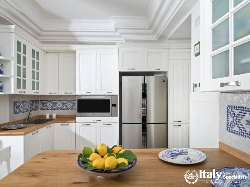 Modern kitchen with stylish white cabinets and a bowl of fresh lemons.