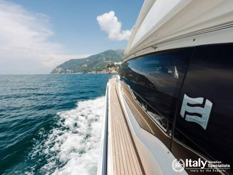 A luxury yacht cruising near the lush, mountainous coastline of the Amalfi Coast.